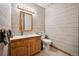 Cozy half bathroom with striped wallpaper, a wooden vanity, and modern fixtures at 14562 W 3Rd Ave, Golden, CO 80401