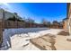 Snow-covered backyard with wooden fence and patio at 16930 E Wagontrail Pkwy, Aurora, CO 80015