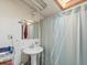 Functional bathroom with pedestal sink, medicine cabinet and shower with light blue curtain at 6310 Tennyson St, Arvada, CO 80003