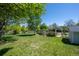Spacious backyard featuring mature trees, manicured lawn, and a decorative garden gate at 1322 Wicklow St, Boulder, CO 80303