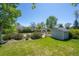 Well-manicured backyard with mature trees, flowering bushes, and a garden shed at 1322 Wicklow St, Boulder, CO 80303