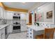 Bright kitchen with white cabinets, stainless steel appliances, and a breakfast bar area with decorative accents at 1322 Wicklow St, Boulder, CO 80303