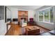 Bright living room with a brick fireplace, built-in cabinets, and a large window overlooking the yard at 1322 Wicklow St, Boulder, CO 80303