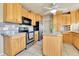 Traditional kitchen with light wood cabinets, stainless steel appliances, and an island at 17769 E Iowa Dr, Aurora, CO 80017