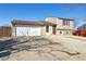 Two-story home with attached garage and a gravel driveway at 18711 E Arkansas Pl, Aurora, CO 80017