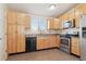 Well-equipped kitchen with light wood cabinets and granite countertops at 18711 E Arkansas Pl, Aurora, CO 80017