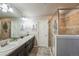 Bathroom featuring double sinks, a walk-in shower with tile surround, and modern fixtures at 16737 Lake Helen Blvd, Mead, CO 80542