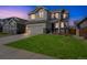 Two-story home with fresh green lawn, showing tasteful exterior design and curb appeal at dusk at 16737 Lake Helen Blvd, Mead, CO 80542