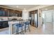 Modern kitchen featuring stainless steel appliances, dark wood cabinetry, and a breakfast bar at 16737 Lake Helen Blvd, Mead, CO 80542