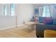 Bright living room with light hardwood floors, comfortable seating, and natural light from large windows at 16737 Lake Helen Blvd, Mead, CO 80542