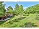 The well-manicured backyard features a lush lawn, mature trees, and ample space for outdoor enjoyment at 19235 Wakonda Way, Monument, CO 80132