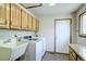 The laundry room has matching washer and dryer, a utility sink, and overhead cabinets at 19235 Wakonda Way, Monument, CO 80132