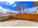 Concrete backyard area with a wood fence, flower beds and blue skies at 4630 E 135Th Way, Thornton, CO 80241