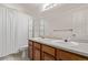 Bright bathroom featuring double sinks, a large mirror, and a shower with a white curtain at 4630 E 135Th Way, Thornton, CO 80241