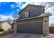 Two story home featuring a gray exterior with brick accents and a dark gray two car garage at 4630 E 135Th Way, Thornton, CO 80241