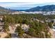 Sweeping aerial view of a home in a densely wooded area with distant mountain and lake views at 9189 Fallen Rock Rd, Conifer, CO 80433