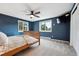 Bright bedroom with wood bed frame, ceiling fan, and views of trees at 9189 Fallen Rock Rd, Conifer, CO 80433