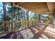 Large deck with wooden railings and scenic wooded views at 9189 Fallen Rock Rd, Conifer, CO 80433