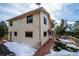 Exterior shot showing the side of the home with a deck and snow-covered yard at 9189 Fallen Rock Rd, Conifer, CO 80433