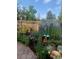 Landscaped backyard featuring vibrant flowerbeds, whimsical decor, and a charming stone pathway at 975 S Queen Way, Lakewood, CO 80226