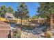 Landscaped backyard features a deck, patio, manicured lawn, and mature trees for serene outdoor living at 975 S Queen Way, Lakewood, CO 80226