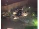Night view of the backyard waterfall feature with decorative stones and a cozy bench at 975 S Queen Way, Lakewood, CO 80226