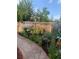 Landscaped backyard with colorful flowers, decorative rocks, and a paved pathway at 975 S Queen Way, Lakewood, CO 80226