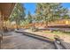 Spacious backyard with a tiered wooden deck, mature trees, and a lush garden at 975 S Queen Way, Lakewood, CO 80226
