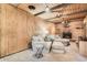 Cozy finished basement with wood paneling, fireplace, and comfortable seating area at 975 S Queen Way, Lakewood, CO 80226