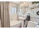 Bathroom featuring a tub, pedestal sink, and tiled walls at 975 S Queen Way, Lakewood, CO 80226