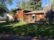 Well-maintained home with cedar siding, a brick chimney, and an inviting front porch at 975 S Queen Way, Lakewood, CO 80226