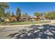 Charming home featuring a well-maintained lawn, wood exterior, brick accents, and a secure black iron fence at 975 S Queen Way, Lakewood, CO 80226