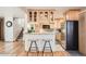 Kitchen with bar seating, light wood cabinets and stainless steel refrigerator at 975 S Queen Way, Lakewood, CO 80226