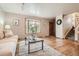 Bright living room featuring hardwood floors, a large bay window, neutral paint, and a classic wooden door at 975 S Queen Way, Lakewood, CO 80226