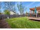 A large grassy backyard with a wood fence and a raised deck with a pergola, ideal for outdoor entertaining at 4510 E 121St Pl, Thornton, CO 80241