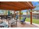An inviting backyard deck features a pergola, comfortable seating, and a manicured lawn, perfect for outdoor enjoyment at 4510 E 121St Pl, Thornton, CO 80241