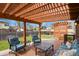 Relaxing backyard deck area featuring comfortable seating, wood pergola, and well-maintained green lawn at 4510 E 121St Pl, Thornton, CO 80241