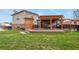 Landscaped backyard with a deck, pergola, and seating area, perfect for relaxation and outdoor entertaining at 4510 E 121St Pl, Thornton, CO 80241