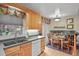 Bright eat-in kitchen features wood cabinets, gray countertops and colorful window treatment at 4510 E 121St Pl, Thornton, CO 80241