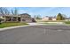 Neighborhood street view of a well-kept home with mature trees and a green lawn at 4510 E 121St Pl, Thornton, CO 80241