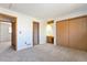 Spacious bedroom with neutral carpet, wood trim, and sliding closet doors at 4203 Owens St, Wheat Ridge, CO 80033