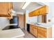 Functional kitchen with wooden cabinets, black appliances, and laminate countertops, ready for cooking at 4203 Owens St, Wheat Ridge, CO 80033