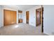 Light-filled main bedroom featuring carpeted floors, closet space, and dressing vanity at 4203 Owens St, Wheat Ridge, CO 80033