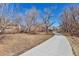 Scenic paved path winding through a natural setting with mature trees at 4203 Owens St, Wheat Ridge, CO 80033