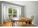 Cozy dining area with hardwood floors, bright window, and a wooden table with four chairs at 6401 S Forest St, Centennial, CO 80121