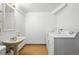 Laundry room with sink, toilet, and modern white washing machine and dryer at 6401 S Forest St, Centennial, CO 80121