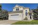 Beige two-story house with a two car garage and manicured lawn at 370 Terra Vista St, Brighton, CO 80601