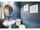 Stylish powder room with a pedestal sink and dark blue walls at 370 Terra Vista St, Brighton, CO 80601