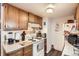 Kitchen with oak cabinets, white appliances, and tiled backsplash, efficient and ready for cooking at 1358 S Irving St # 53, Denver, CO 80219