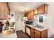 Kitchen with oak cabinets, white appliances, and tiled backsplash, efficient and ready for cooking at 1358 S Irving St # 53, Denver, CO 80219